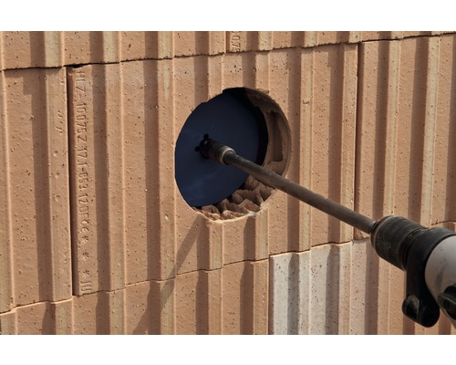 Perceuse perçant un trou dans un mur de briques