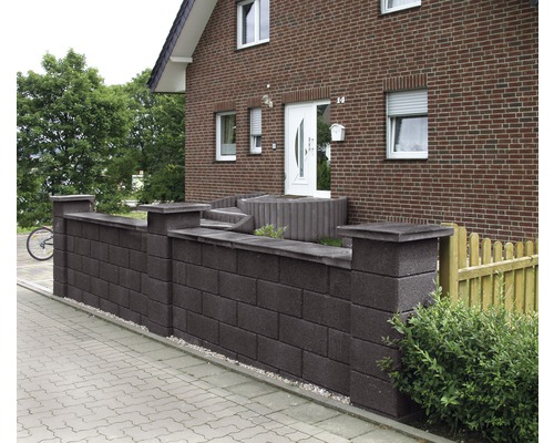 Mur en béton devant une maison avec des pavés