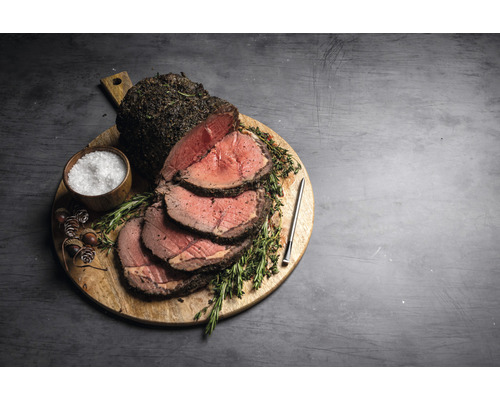 Rosbif sur planche à découper en bois avec sel, herbes et thermomètre à viande