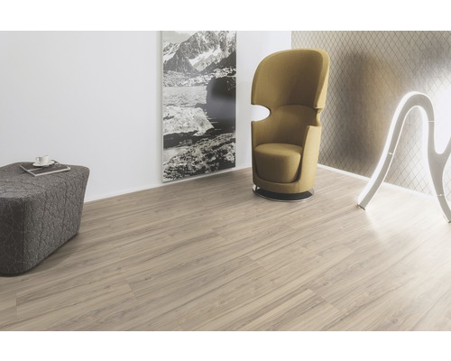 Espace de vie avec sol stratifié clair, fauteuil, tabouret et décoration