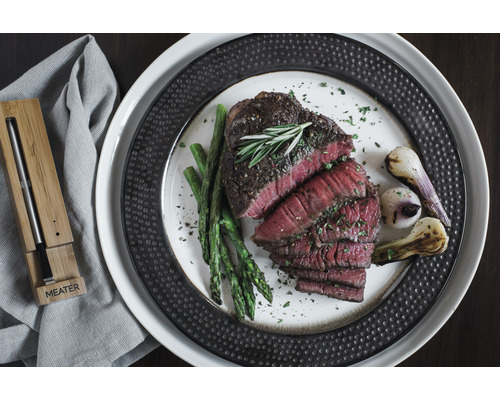 Plat avec steak, asperges et oignons, ainsi qu''un thermomètre à viande de Meater