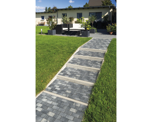 Gartenlandschaft mit gepflastertem Weg und Sitzgruppe