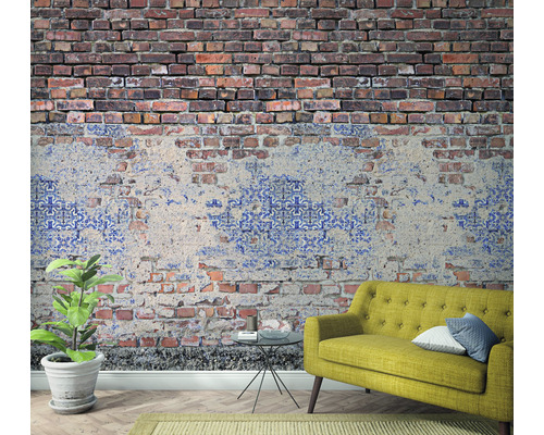 Zimmer mit einer Wandtapete in Ziegeloptik, einem Sofa und einer Zimmerpflanze.