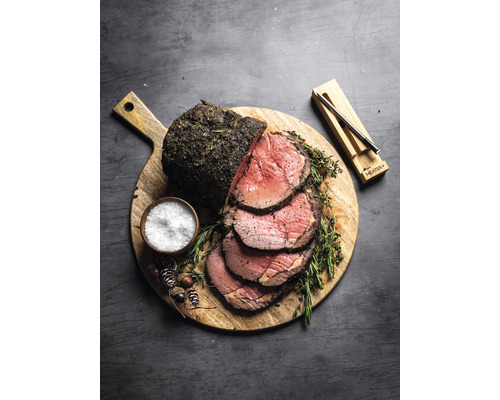 Rôti de boeuf sur planche en bois avec sel et thermomètre