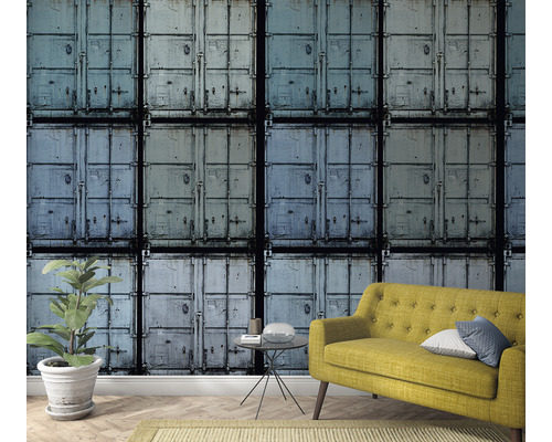 Vue d''une pièce avec un papier peint à motif de conteneurs, un canapé jaune et une plante d''intérieur