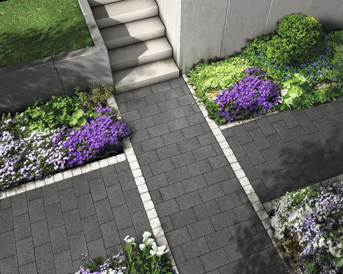 Allée de jardin avec pavés et parterres de fleurs