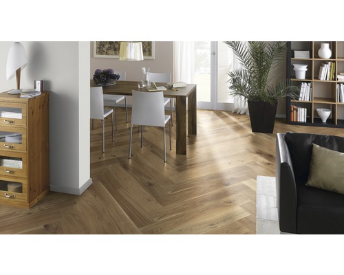 Innenraumszene mit Fischgrätparkett, Esstisch und Sitzgelegenheiten, Bücherregal und Zimmerpflanze