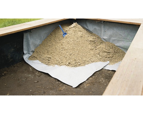 Sandkasten gefüllt mit Spielsand und einer kleinen Schaufel