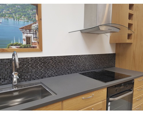 Scène de cuisine avec évier, robinet, carreaux de mosaïque, plaque de cuisson, four et hotte aspirante.