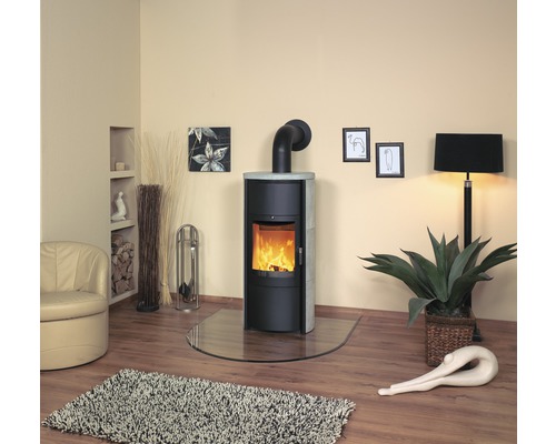 Wohnraum mit Kaminofen, Glasbodenplatte, Sessel, Teppich und Dekoration