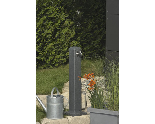 Gartenszene mit Wasserzapfsäule, Gießkanne und Bepflanzung