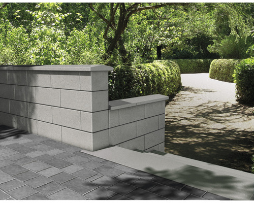 Mur de jardin en blocs de pierre avec revêtement et pavés dans le jardin