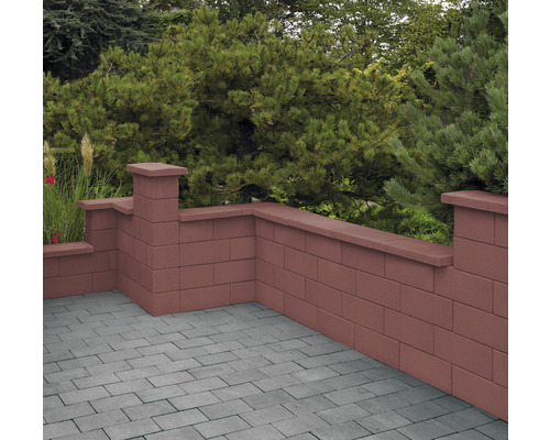 Muret de jardin en blocs de béton avec des plantes en arrière-plan