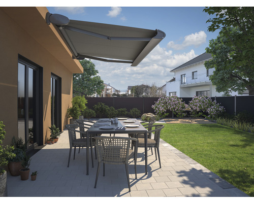 Terrasse avec store, table et chaises dans un jardin