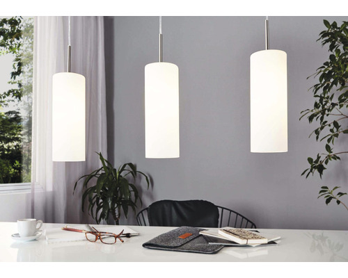 Drei zylinderförmige Pendelleuchten über einem Tisch