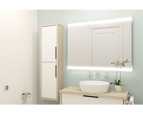 Badezimmer mit Waschtisch, beleuchtetem Spiegel und Hochschrank