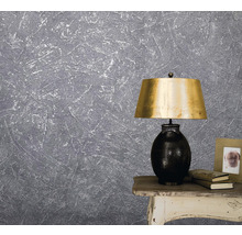 Graue Strukturtapete mit Lampe auf einem Tisch