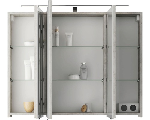 Armoire de toilette ouverte avec étagères en verre, prise de courant et divers articles de salle de bains