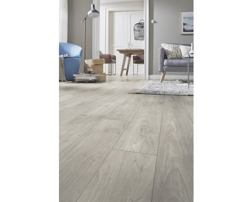 Salon lumineux avec sol stratifié imitation bois, canapé et fauteuil