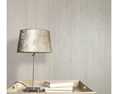 Szene mit einer strukturierten Tapete, einer Lampe und Büchern auf einem Tisch