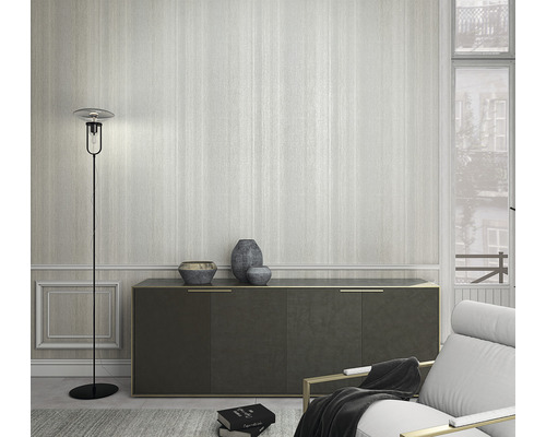 Wohnzimmer mit Stehlampe, Kommode und Sessel vor einer gestreiften Tapete