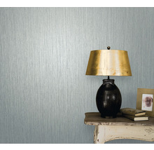 Nahaufnahme einer Wand mit Strukturtapete neben einem Tisch mit Lampe