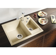 Beige Küchenspüle mit zwei Becken und Wasserhahn auf einer Arbeitsplatte.