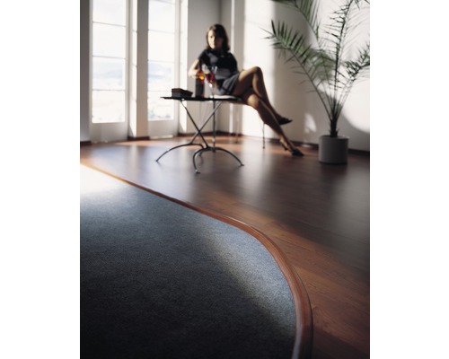 Innenraum mit Teppichboden, Holzfußboden und Frau am Tisch