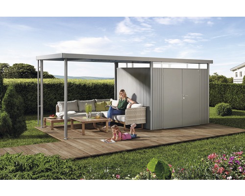 Szene mit Gartenhaus mit Loungeecke auf Holzterrasse im Garten