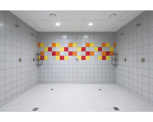 Gefliester Duschraum mit bunten Akzenten und Ablaufrinnen