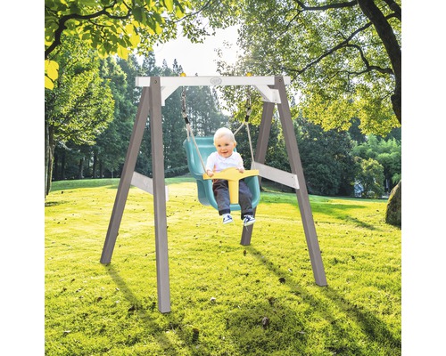 Kinderschaukel mit Baby auf einer Wiese