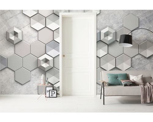 Salon décoratif avec papier peint mural hexagonal, porte et canapé.