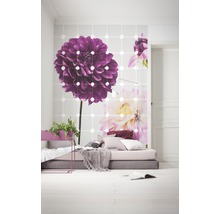 Heller Raum mit Fototapete mit Blumenmotiv, niedrigem Bett und Zimmerpflanzen
