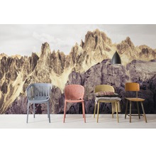 Szene mit vier Stühlen vor einer Fototapete mit Bergmotiv und einer Hängelampe