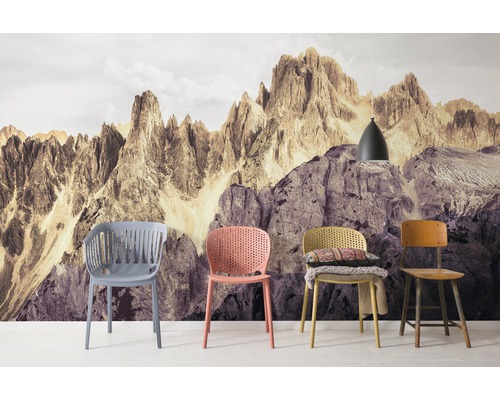 Szene mit vier Stühlen vor einer Fototapete mit Bergmotiv und einer Hängelampe