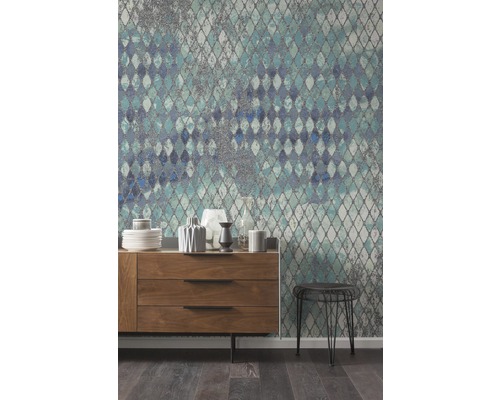 Wohnzimmer mit Kommode, Hocker und gemusterter Tapete in Rautenoptik