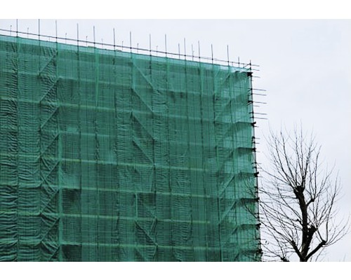 Ein Gebäude mit Baugerüst und Schutznetz.