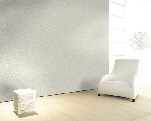 Pièce claire avec papier peint à motifs, fauteuil et objets de décoration