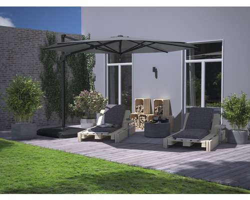 Terrasse mit Sonnenschirm, Liegestühlen und Holzkisten