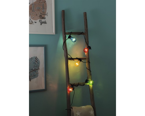 Guirlande lumineuse avec ampoules colorées sur une échelle en bois
