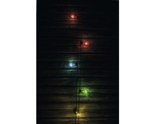 Guirlande lumineuse décorative avec des ampoules multicolores devant un mur en bois