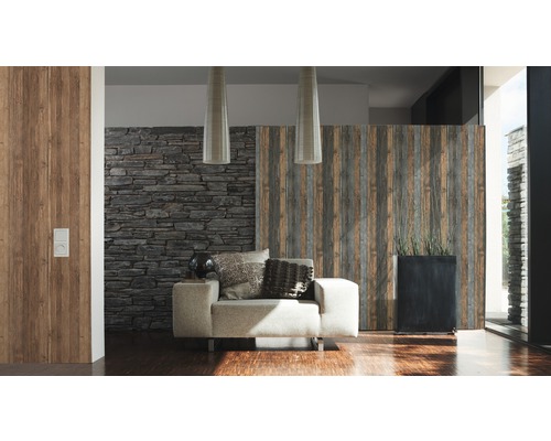 Salon avec fauteuil, coussins décoratifs, mur décoratif en pierre et mur en bois