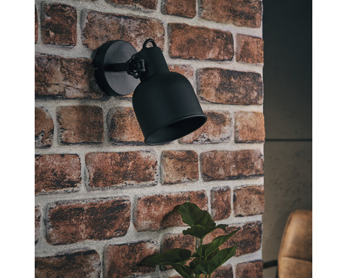 Applique murale noire sur un mur en briques