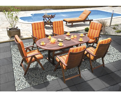 Scène de jardin avec table ovale en bois, six chaises avec coussins rayés, piscine et chaise longue