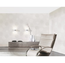 Wohnzimmer mit gemusterter Tapete, Sessel und Holzkommode