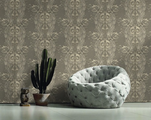 Raumansicht mit gemusterter Tapete, Sessel, Kaktus und Dekoration