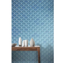 Szene mit einer blauen Tapete mit Fischschuppenmuster und einem Holztisch mit Dekoration