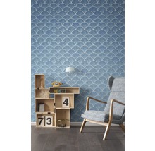 Raumansicht mit blauer Tapete mit Muschelmuster, Regalwürfel und Sessel