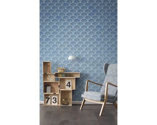 Vue d''une pièce avec papier peint bleu à motif coquillage, étagère cubique et fauteuil