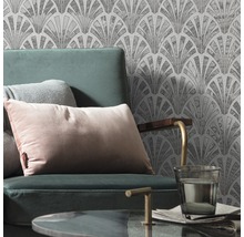 Szene mit Sessel, Kissen und gemusterter Tapete im Art-Déco-Stil